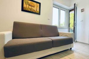 um sofá sentado numa sala de estar num quarto em Alba - Parcheggio gratis, fronte caserma e clima em Ascoli Piceno