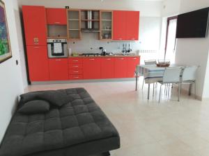 a kitchen with red cabinets and a table with chairs at Pirandello45 - zona universitaria in Campobasso