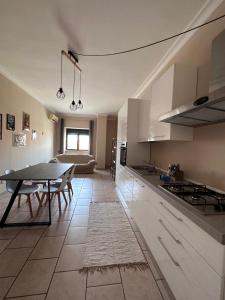 a kitchen with a table and a dining room at La Maison de Marianne in Trepuzzi