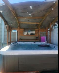 eine große Badewanne in einem Zimmer mit Holzdecke in der Unterkunft bassement whit jackuzzi and pool in Copiague