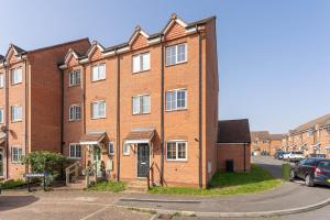 a red brick building with a car parked in front of it at Newly Refurbished Townhouse, Free Parking & Garden in New Bilton