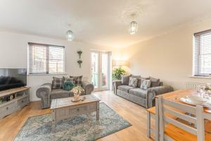 uma sala de estar com um sofá e uma mesa em Newly Refurbished Townhouse, Free Parking & Garden em New Bilton