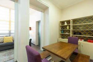 ein Esszimmer mit einem Tisch und lila Stühlen in der Unterkunft Ola Lisbon - Campo Pequeno in Lissabon