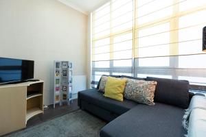 - un salon avec un canapé et une télévision dans l'établissement Ola Lisbon - Campo Pequeno, à Lisbonne