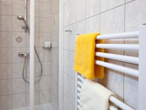 y baño con ducha y toalla amarilla. en Appartement NOVA, en Graz