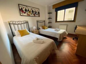 a bedroom with two beds and a window at Brigantia Coruña in A Coruña