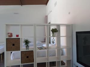 estante de libros blancos en una habitación con cama en Huerta Alegría, en Casariche