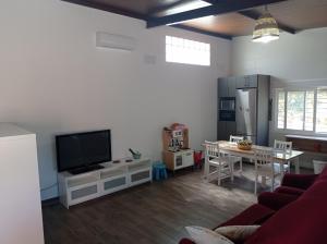 sala de estar con sofá, TV y mesa en Huerta Alegría, en Casariche