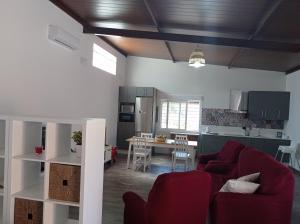 sala de estar con sofá rojo y cocina en Huerta Alegría, en Casariche