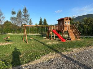 einen Spielplatz mit einer roten Rutsche und einem Haus in der Unterkunft Apartment Eneya in Pazarić