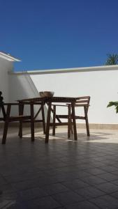 a wooden picnic table sitting on a tiled floor at Peri Peri Holiday Home - Siracusa in Solarino