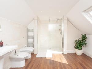 a white bathroom with a toilet and a shower at Pass the Keys Breathtaking view Family home Leeds in Leeds
