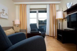 a living room with a couch and chairs and a television at Hapimag Resort Aalborg in Westerland (Sylt)