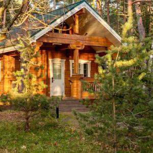 a log cabin in the woods with a white door at Sea Home Cottages in Ozerki