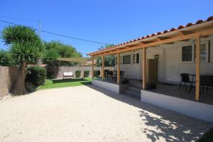 a house with a patio with a table and chairs at Brand new house with garden, next to the beach in Áyios Ilías
