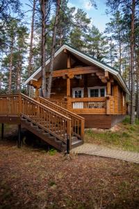 a log cabin in the woods with a large deck at Sea Home Cottages in Ozerki