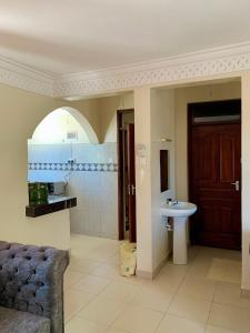 Classic Shanzu 2bedroom apartment في مومباسا: حمام مع حوض ومرحاض