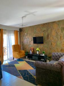 Classic Shanzu 2bedroom apartment في مومباسا: غرفة معيشة مع أريكة وتلفزيون