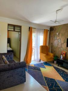 Classic Shanzu 2bedroom apartment في مومباسا: غرفة معيشة مع أريكة وكرسي