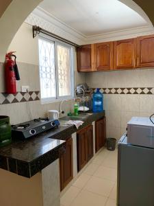 蒙巴薩的住宿－Classic Shanzu 2bedroom apartment，厨房配有木制橱柜、水槽和窗户。