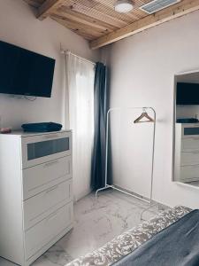 1 dormitorio con vestidor, TV y cama en Apartamento KENOA metropolitano, en Madrid