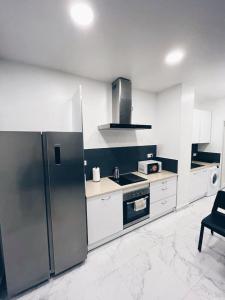 a kitchen with a refrigerator and a stove top oven at Apartamento KENOA metropolitano in Madrid
