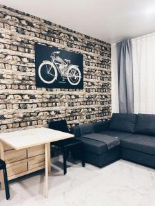 a living room with a couch and a brick wall at Apartamento KENOA metropolitano in Madrid