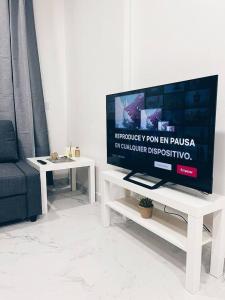 a living room with a flat screen tv on a white table at Apartamento KENOA metropolitano in Madrid