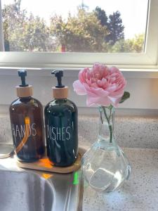 duas garrafas de sabão e uma flor rosa num vaso em NEW private tiny home near GreenLake/Lightrail/I-5 em Seattle