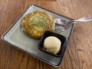 Un plato con un pastel y helado sobre una mesa. en Spider House Aparthotel, en Pamporovo 30 fotos más