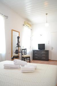 Villa Liogerma في بانورموس سكوبيلوز: غرفة نوم عليها سرير وفوط بيضاء