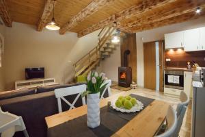 a kitchen and living room with a table and a couch at Chata Malý Sokol in Smižany