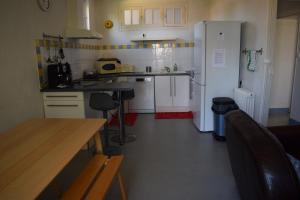 a small kitchen with a counter and a refrigerator at Logis de Fornel in La Rochefoucauld