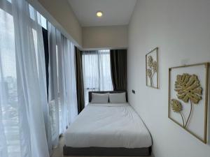 een bed in een kamer met een groot raam bij Klcc suites at star - 2 bedroom in Kuala Lumpur