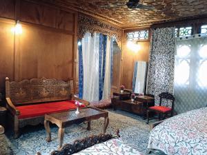 a bedroom with a bed and a couch and a table at Jacqueline houseboat in Srinagar +13 photos