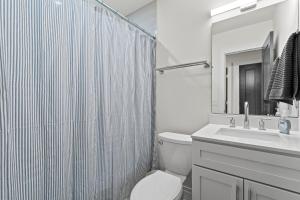 Baño blanco con aseo y lavamanos en West Taylor Run Hotel, en Alexandria