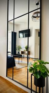 einen Spiegel im Wohnzimmer mit einer Pflanze in der Unterkunft Chez Ethan, 5 min à pied de l'Acropole in Athen