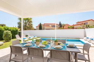 um pátio com uma mesa e cadeiras e uma piscina em Villa Perez em Cala'n Bosch