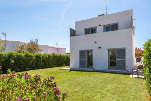 uma casa branca com um relvado à frente em Villa Perez em Cala'n Bosch