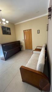una sala de espera con tres sofás y un órgano en Bernardo’s Departamento céntrico para 2 o hasta 3 personas en Sucre