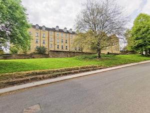 a large yellow building on the side of a road at Fivehill Apartment, Long Stay, 4 Showers, Sleeps 10, Free Parking, in Sheffield