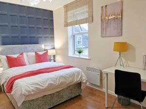 um quarto com uma cama, uma secretária e uma janela em Fivehill Apartment, Long Stay, 4 Showers, Sleeps 10, Free Parking, em Sheffield