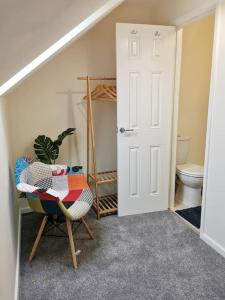 a room with a bathroom with a toilet and a chair at Fivehill Apartment, Long Stay, 4 Showers, Sleeps 10, Free Parking, in Sheffield