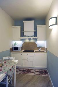 a kitchen with white cabinets and a table and a microwave at San Gimignano, Siena La casina di Zigino in San Gimignano