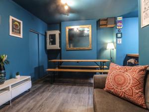 uma sala de estar com um banco e paredes azuis em Comfortable Margate Home em Margate