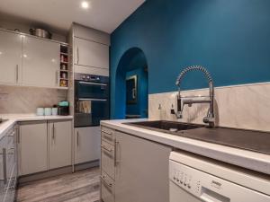 a kitchen with a sink and a blue wall at Comfortable Margate Home in Margate