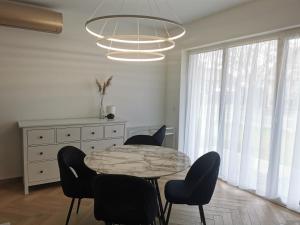 a dining room with a marble table and chairs at Apartament na Irysowej in Dobrzeń Wielki