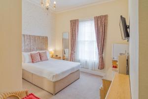 ein Hotelzimmer mit einem Bett und einem Fenster in der Unterkunft The Mariners - Torquay in Torquay