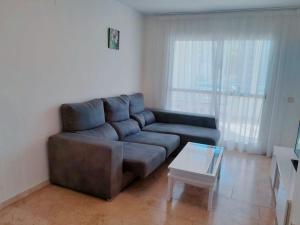 ein Wohnzimmer mit einem Sofa und einem Couchtisch in der Unterkunft Las torres Alquilevante in Benidorm