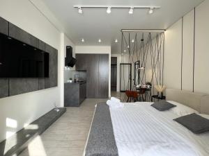 1 dormitorio con 1 cama grande y TV en la pared en LUX Аппартаменты SMART #2, en Pavlodar